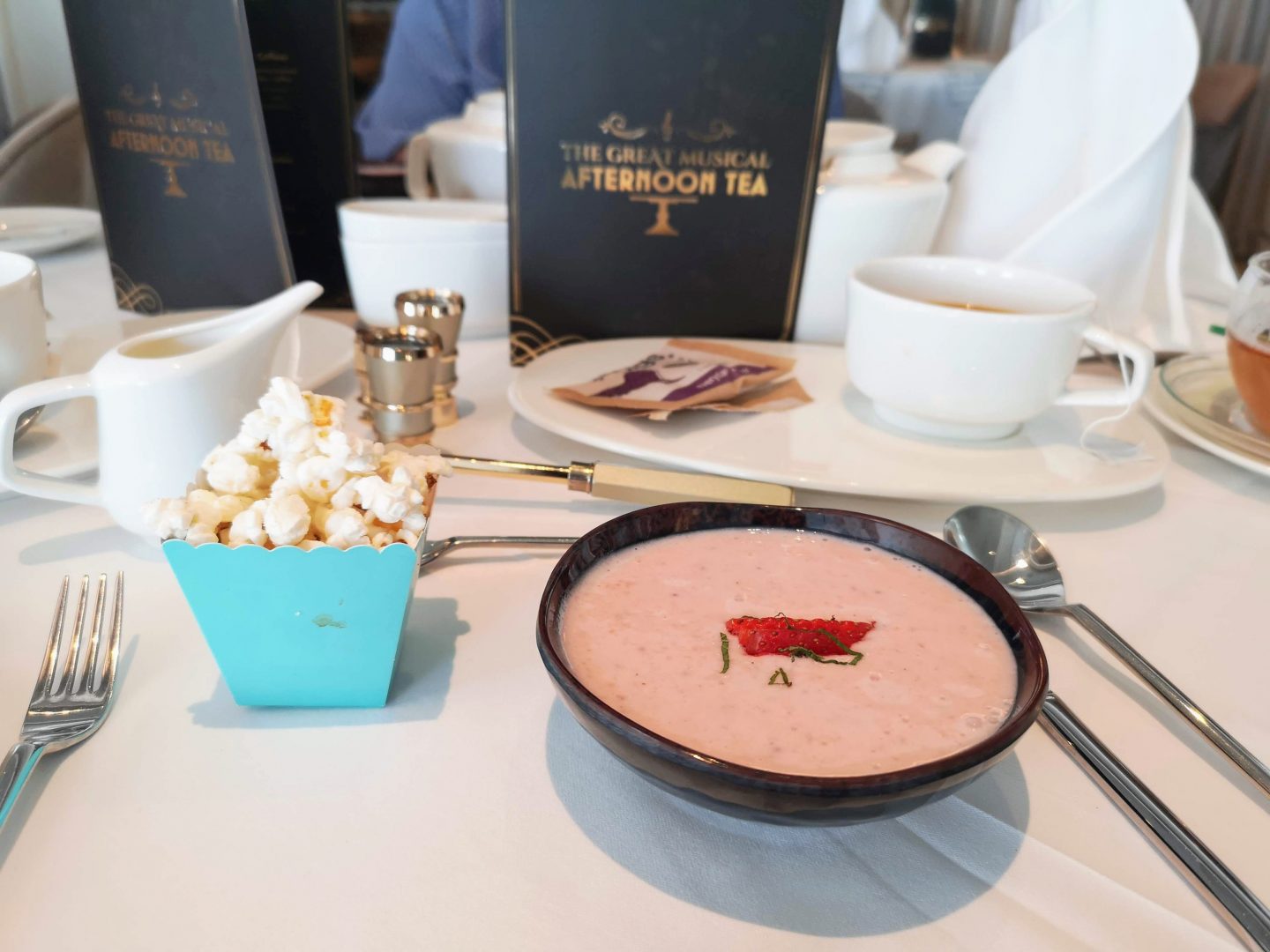 A bowl of strawberry soup with popcorn